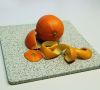 Eine Orange  - daneben Orangenschalen. Orangenöl als Ausgangsmaterial für Epoxide: fugenfreier Terrazzo-Fußbodenbelag mit orangenölhaltigem Leinöl-epoxid.